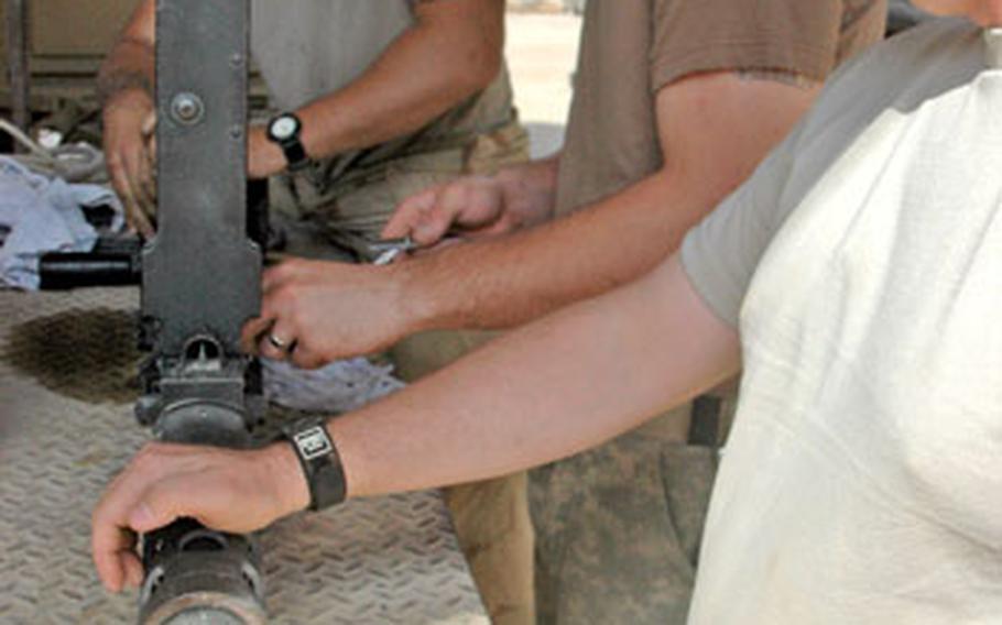 Reassembling a .50-caliber machine gun for re-positioning on a truck are, left to right, Spc. Marquis Goddard, 20, a native of Beaufort, S.C., Spc. Shawn Nelson, 23, of East Liverpool, Ohio, and Sgt. Anthony Cantrell, 35, from Longview, Wash.