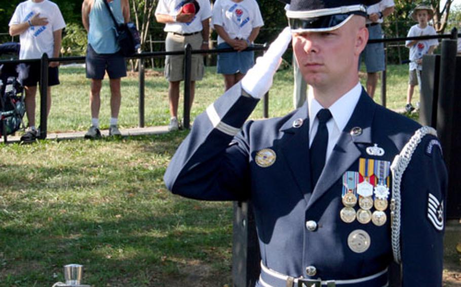 Air Force Tech. Sgt. Joshua Hodgin, director of the Pentagon’s tour program, salutes as the national anthem is sung before Sunday’s Freedom Walk in Washington.