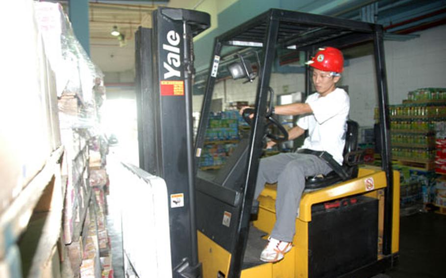 Warehouse foreman Muto Takuya operates a forklift at the Camp Foster Commissary in Okinawa. This month, commissaries worldwide will be hosting case-lot sales, with many bulk goods dramatically discounted.
