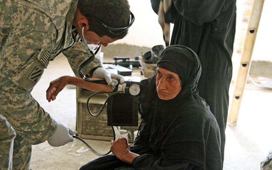 Pfc. Josue Roman, 22, of Hatillo, Puerto Rico, checks the blood pressure of an Iraqi woman during a medical relief operation Tuesday in the village of Al Arabia, on the southeastern outskirts of Baghdad. Soldiers with Troop A, 3rd Squadron, 1st Cavalry Regiment treated more than 100 villagers during the operation. At least that many were turned away for lack of time.