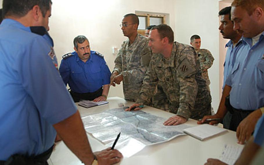 Capt. Chris Haun, center right, and other members of the 1st Brigade Combat Team's 3rd Battalion, 69th Armor Regiment, work with Iraqi police Wednesday in Salam, Anbar province.