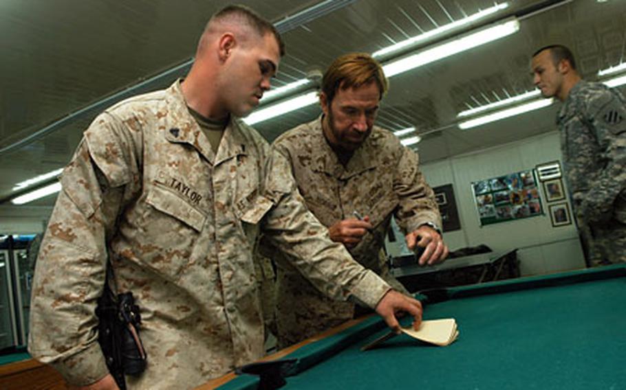 Cpl. Donald Taylor, 24, of Greenville, S.C., got some martial-arts information and a writing sample from the master himself when Chuck Norris came to Camp Blue Diamond on Friday.