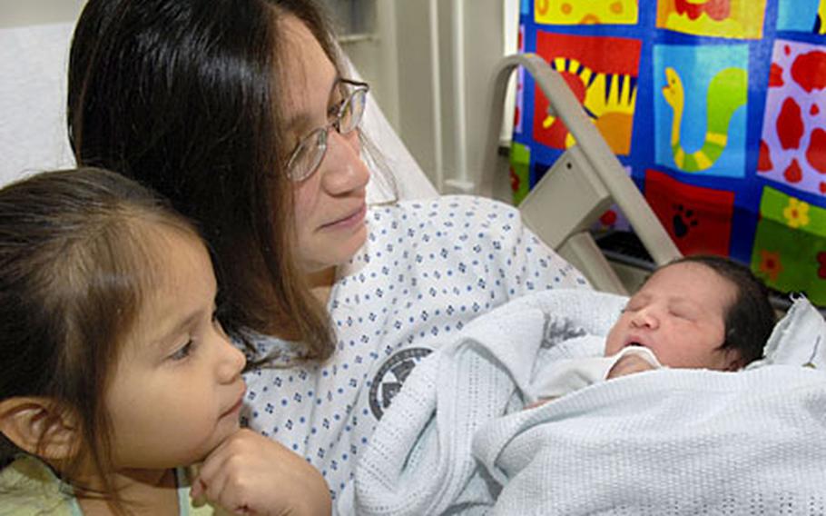 Angelina and 3-year-old Esperanza enjoy new-born Isabella in the Mother/Baby Ward at Landstuhl Regional Medical Center on Friday.