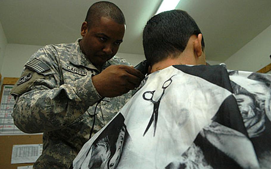 U.S. Army Sgt. Cameron Carter gives free, full service haircuts on the fly in Iraq. This is the second tour in Iraq in which the 30 year-old New Orleans native brought his clippers. He cut Lt. Carlos Alvarez’s hair on Friday at Camp Blue Diamond in al Anbar province.