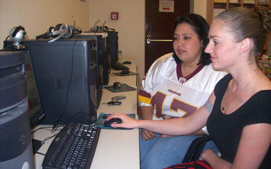 Second Cavalry Regiment spouses Nicole Heller (left) and Danielle Wilding check out equipment in the Army Community Services Yellow Ribbon room at Vilseck. The computers allow families to video conference with soldiers downrange.