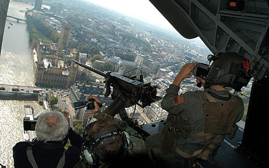 Passengers on a MH-53M Pave Low snap photos of the Parliament as it travels along the River Thames in central London. A formation of five Pave Lows hovered past many tourist attractions as part of its final flight.