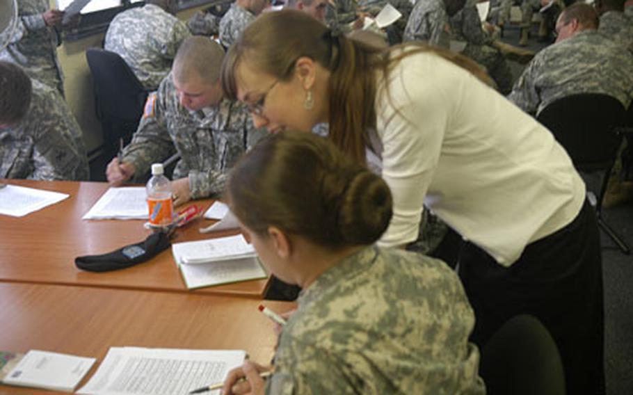 Linnea Tippett, instructor of the Iraqi Headstart program, helps students during an Arabic writing exercise at the education center in Baumholder.