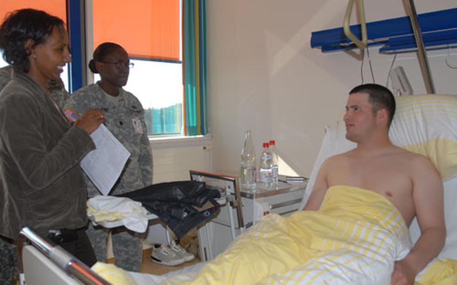 Grafenwöhr nurse case manager Helen Wise, left, and Grafenwöhr Medical Center commander Lt. Col. Telita Crosland talk to Eschenbach Hospital patient Pvt. Calvin Woods.