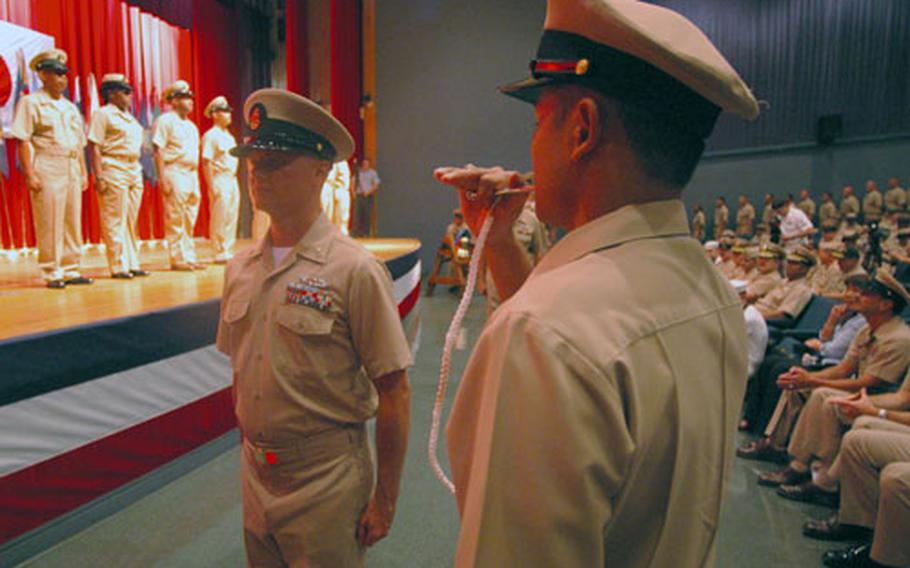 Newly pinned chief petty officers are piped into the Chief Petty Officer’s Mess at the Fleet Theater on Yokosuka Naval Base. This marked the culmination of an arduous six-week induction process, ending the the Navy’s newest chief petty officers being presented their anchors and combination covers in pinning ceremonies conducted throughout the Navy.