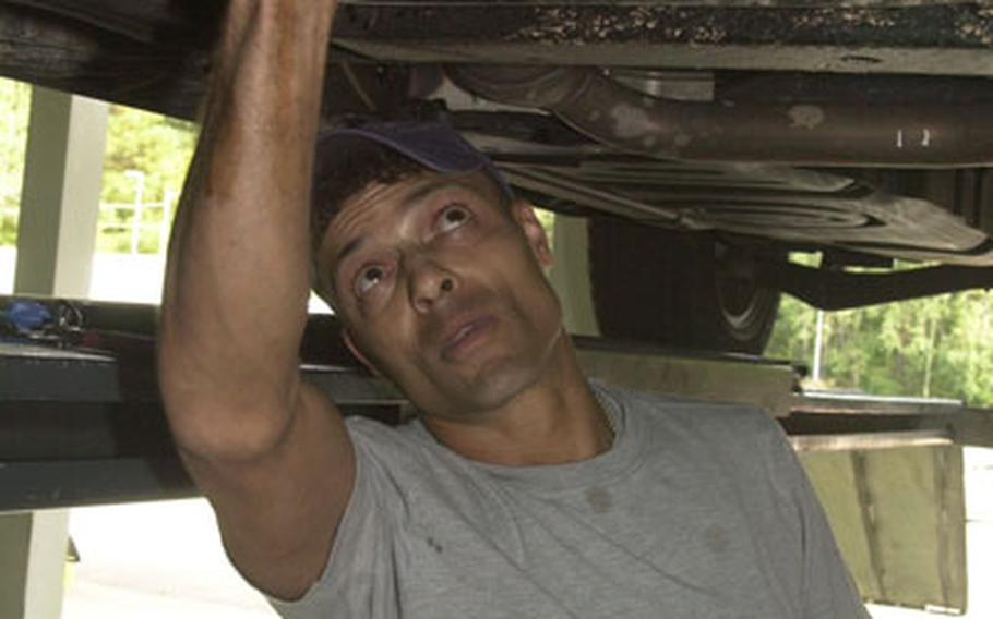 Aaron Cooper, an employee at the Auto Skills Center at Pulaski Barracks in Kaiserslautern, Germany, changes the oil in a vehicle on Monday. Air Force and Army auto skills centers in the Kaiserslautern area have seen the number of customers skyrocket with the closure of the Army and Air Force Exchange Service's Car Care Center garage last July. Kaiserslautern no longer has an AAFES garage to service the more than 50,000 Americans who live in the area.
