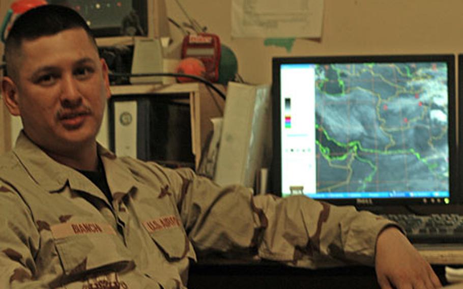 Tech. Sgt. Greg Bianchi sits near his computerized weather forcecasting equipment in the air traffic control tower at Bagram Airfield, Afghanistan.