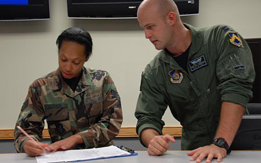 Capt. Dave “Bull” Anderson, right, talks with Senior Airman Jamilya Jackson at Kunsan Air Base, South Korea, earlier this month. Anderson, an F-16 pilot, was awarded the Distinguished Flying Cross last month for killing six insurgents who were attacking American troops on the ground during a 2006 deployment to Iraq.