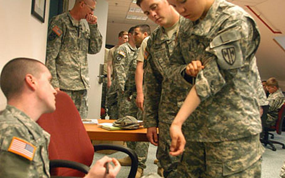 Pvt. Emily Faden, right, of 1st Platoon, 554th Military Police Company, shows where she received a tuberculosis detection shot to Sgt. Justin Rash, a medic with the Patch Health Clinic. The shots were given to determine whether Faden and other soldiers had contracted TB during their 15-month deployment to Iraq.