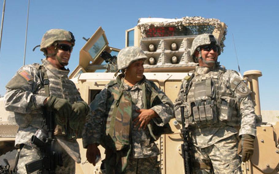 From left to right, U.S. Army Sgt. Stephen M. Burnham, interpreter Abraham Khadir and Sgt. Jeff Reick stand in front of their PSYOP loudspeaker Humvee in Fallujah, Iraq.