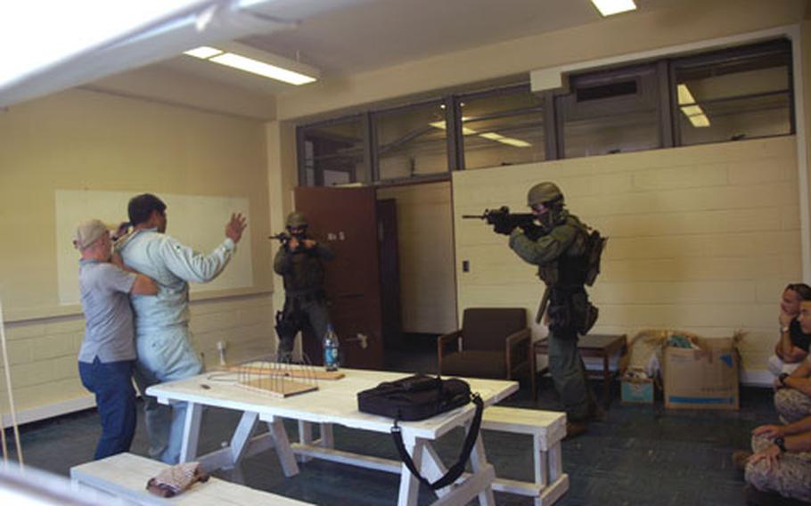 Marines of the Camp Foster, Okinawa, special reaction team face off with a mock terrorist, who was holding two hostages. Army officials hosted the terrorism drill at Port Naha on Okinawa.