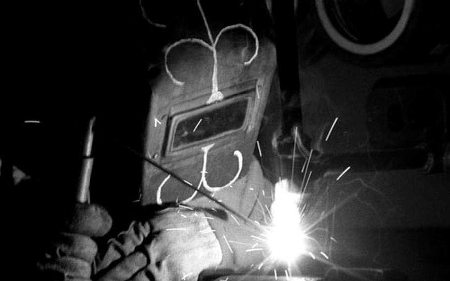 Hull technician Deano Marchese works on a high-pressure steam line on the Little Rock.