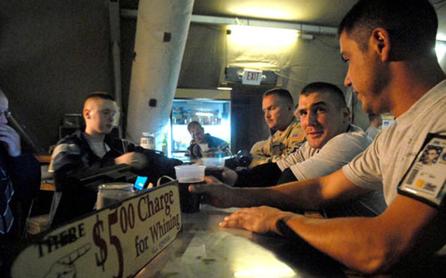 Airmen get a couple of drinks from the bar at Pete&#39;s Place on Manas Air Base. The establishment has a two-drink maximum for all servicemembers.