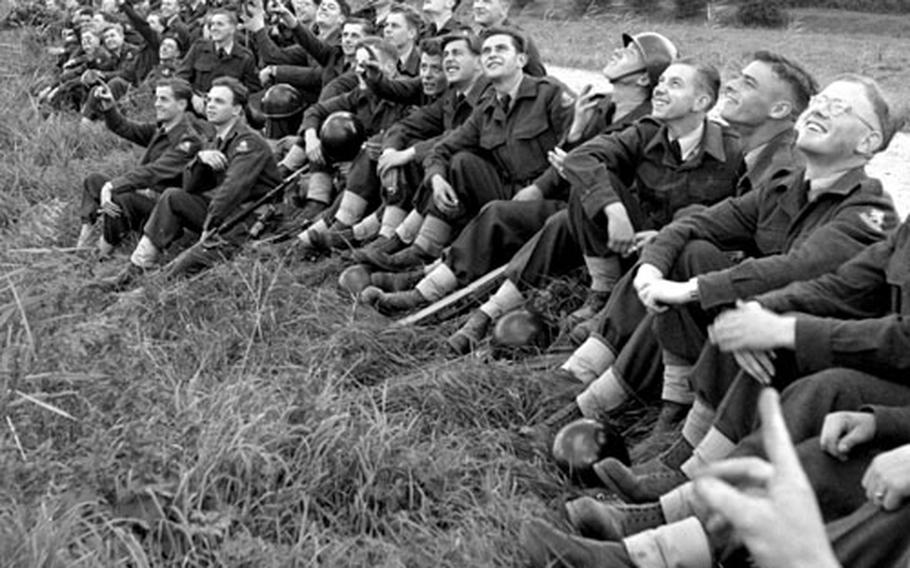 Dutch airmen line a canal near Nijmegen to watch air drops by American paratroopers in September, 1953.