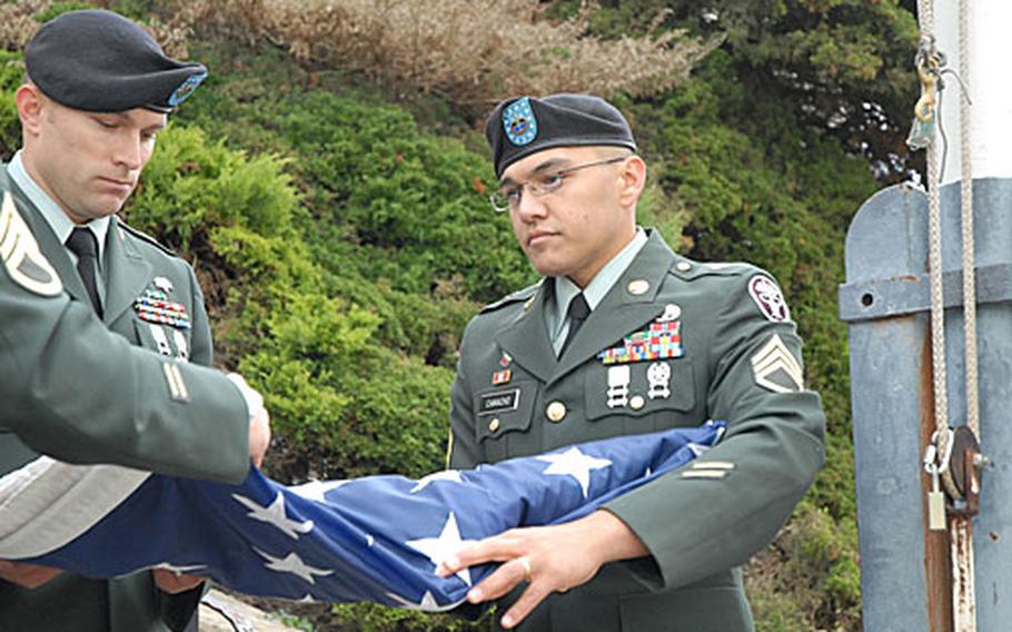 Staff Sgts. Jason Bernard, left, and Gabriel Camacho of Headquarters and Headquarters Company of the Bavaria Medical Department Activity, fold the Würzburg American Hospital flag for the final time Friday during a retreat ceremony. The hospital served American soldiers and families since the end of World War II.