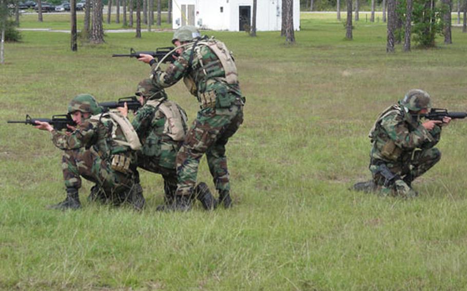 Expeditionary Combat Skills students assume fighting positions while conducting bailout training with Humvees.