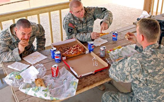 Drew Brown/StripesSgt. William McCormick (left), 24, of Savannah, Tenn., Pfc. Dustin Roscoe, 21, of Burleson, Texas and Capt. Brian Mason (right), 25, of Philadelphia chose sandwiches and pizza over traditional Thanksgiving fare Thursday at Contingency Operating Base Speicher in northern Iraq. They said Thanksgiving was just like any other day in Iraq and saw no particular reason to celebrate. They are with the 0411 Military Transition Team, 1st Brigade, 101st Airborne Division. 