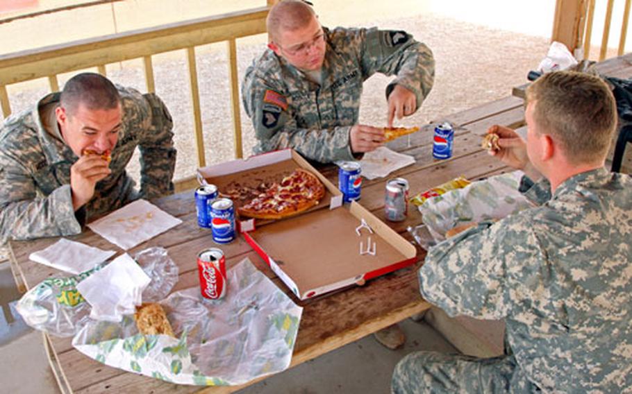 Sgt. William McCormick (left), 24, of Savannah, Tenn., Pfc. Dustin Roscoe, 21, of Burleson, Texas and Capt. Brian Mason (right), 25, of Philadelphia chose sandwiches and pizza over traditional Thanksgiving fare Thursday at Contingency Operating Base Speicher in northern Iraq. They said Thanksgiving was just like any other day in Iraq and saw no particular reason to celebrate. They are with the 0411 Military Transition Team, 1st Brigade, 101st Airborne Division.