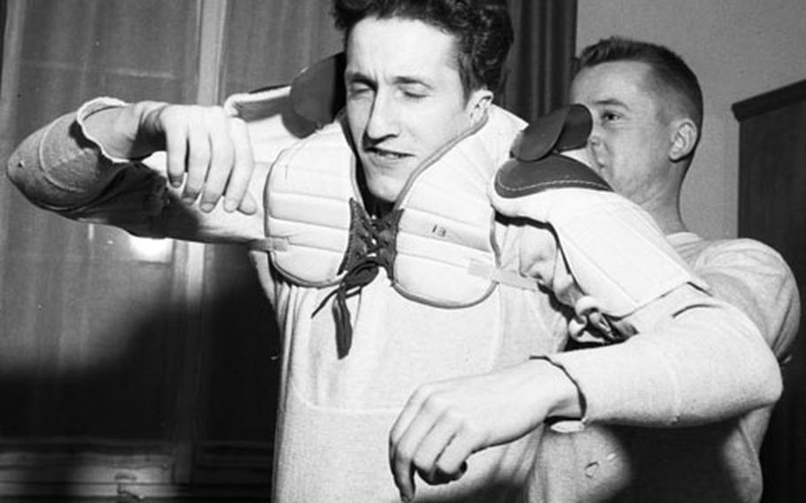 Vic Osowetski helps Ron O&#39;Meara put on his pads before they leave for a game.