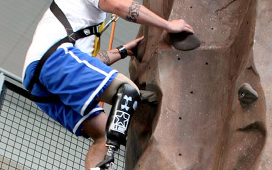 Army Staff Sgt. William Corp scales the climbing wall spanning the third and fourth floors of the Center for the Intrepid. Corp lost his right leg in an IED attack in Iraq earlier this year.