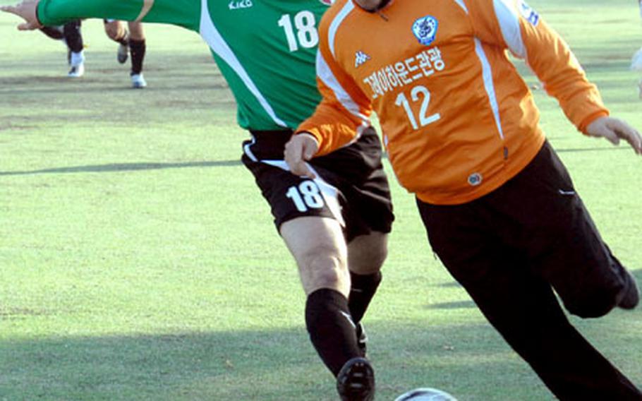 A U.S. soccer player, left, on the 94th Military Police Battalion team tries to kick the ball away from a South Korean player. Their teams played Friday during the first game held by the Korea America Good Neighbor Sports Association.
