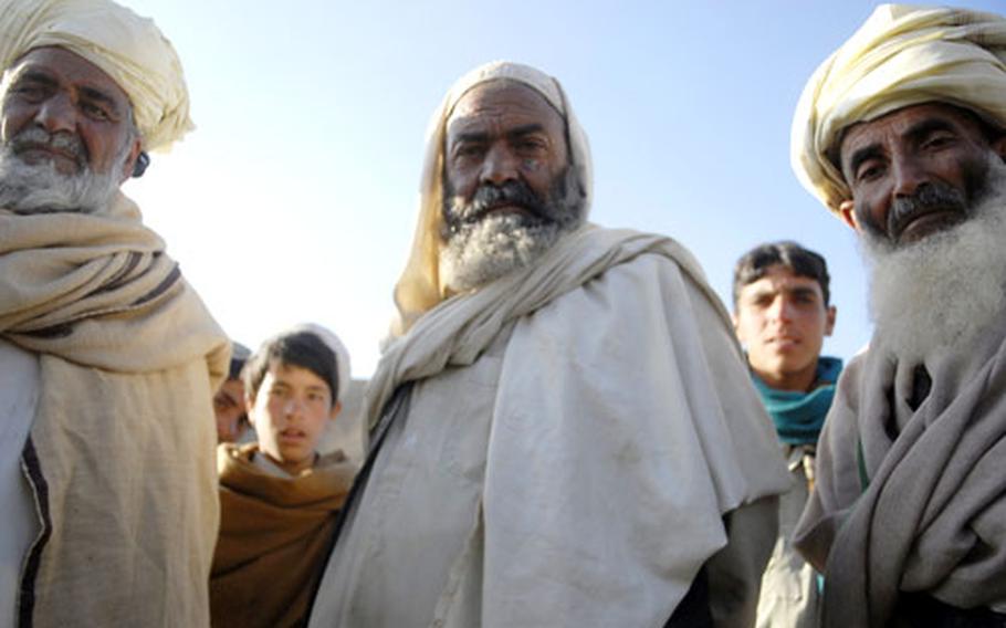 Village elders in Spise gaze into the camera of a photographer accompanying U.S. troops and Afghan police on a trip to assess the needs of remote villages of Logar Province. The people of the village get few visitors.