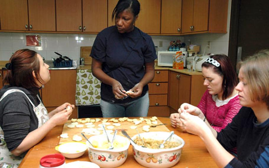 Olga Escano, Shannon Givens, Elena Blessig and Christy Stepanek (left to right) talk Friday while they make pierogis at the Pear Blossom Cottage on Camp Red Cloud in Uijeongbu. The cottage offers cooking classes nearly every month for spouses of soldiers.