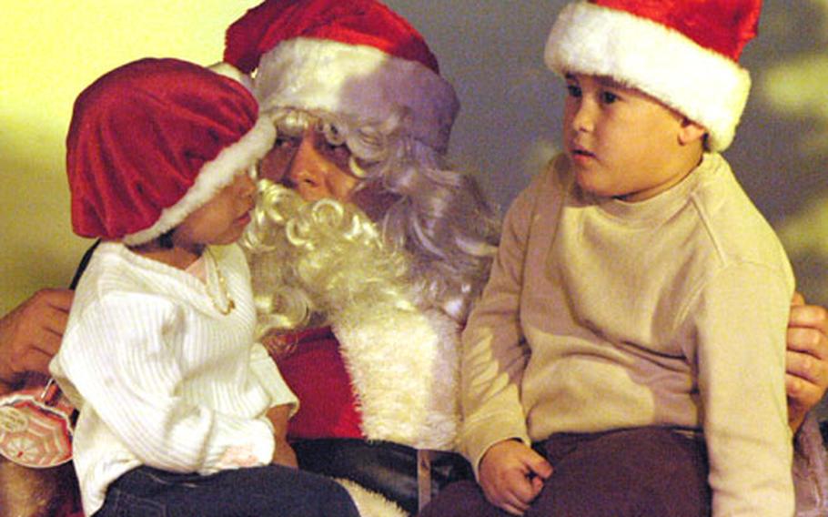 Khalia Jadan, 3, and her brother, Kerik, 5, pose with Santa Claus on Sunday during the 173rd Airborne Brigade Combat Team rear detachment’s holiday party at Caserma Ederle. Kids got a chance to work on a variety of crafts they can send to their parents, many of whom are deployed to Afghanistan.