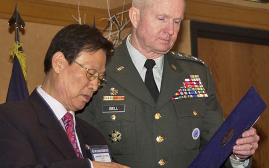 ROK-U.S. Alliance Friendship Society chairman Suh Jin-sup tells Combined Forces Command commander Gen. B.B. Bell about the Korean name the organization picked for the general during a ceremony Monday night on Yongsan Garrison, South Korea. Bell was given the name Baek Bo-guk.