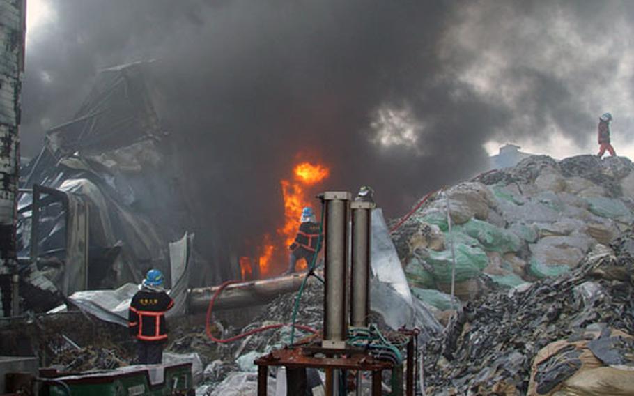Gunsan City, South Korea, firefighters battle a warehouse blaze Monday with help from firefighters from Kunsan Air Base's 8th Fighter Wing. The two fire departments train together periodically and reinforce each other when needed.
