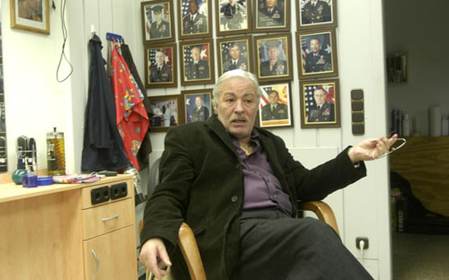 Giuseppe Muré sits in his barber shop at Kelley Barracks in Stuttgart, Germany, in front of autographed portraits of Gens. Peter Pace, William E. "Kip" Ward, Wesley Clark and others. Muré, a barber in the Stuttgart military community for 21 years, is resisting an attempt by AAFES to change the terms of his contract.