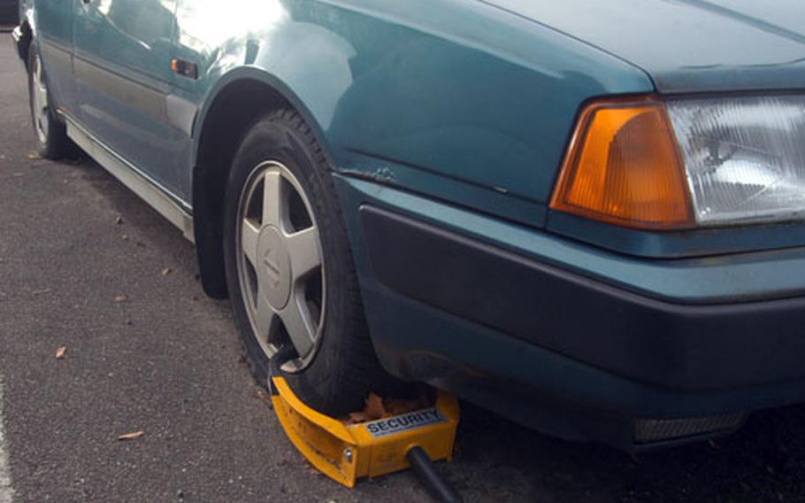 A green Volvo sits motionless with a wheel clamp on its front tire after being labeled abandoned on RAF Lakenheath. The base sees an average of 350 to 450 vehicles each year that are considered abandoned. So far this year, 93 vehicles have been towed away and sent to a local scrap yard.