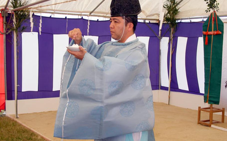 Akira Taba, a Shinto priest, conducts a blessing Wednesday at the site of what will be a 43,000-square-foot consolidated enlisted club on Camp Foster. The salt symbolizes the purification of the construction site.