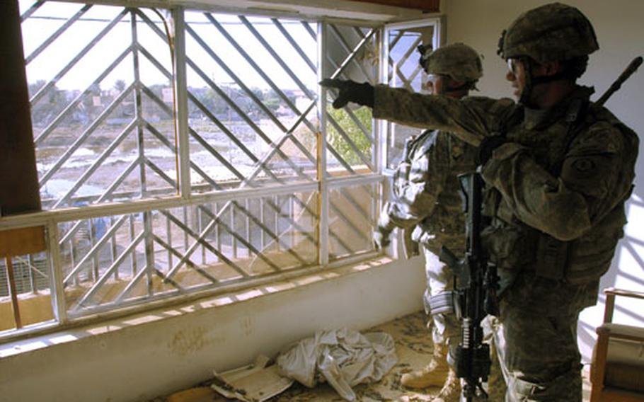 First Lt. Andrew Teague, 24,of Glen Ellyn, Ill., who leads 4th Platoon, Company G, 3rd Squadron, 2nd Cavalry (Stryker) Regiment, points out enemy positions from a room where his soldiers took cover Sept. 18 during a battle with insurgents in Baghdad&#39;s Hadar neighborhood.