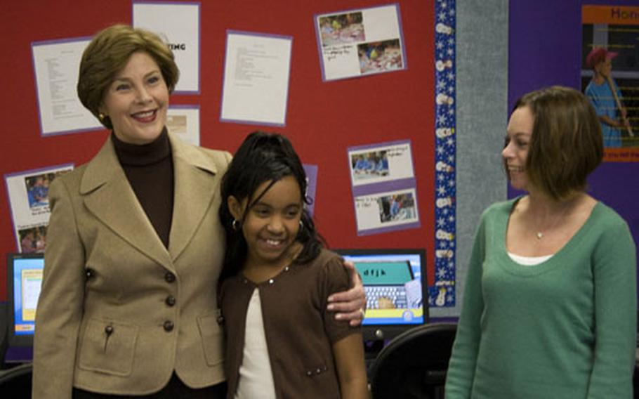 Taylor Rice, 10, (center) shares a hug with First Lady Laura Bush after she gave Mrs. Bush a tour of the Learning Center at Andrews Air Force Base’s youth center Wednesday, Dec. 5, 2007. Rachel Seagraves (right) is a school-age programming assistant at the youth center.