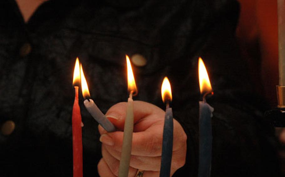 Detail shot of lighting a menorah candle.