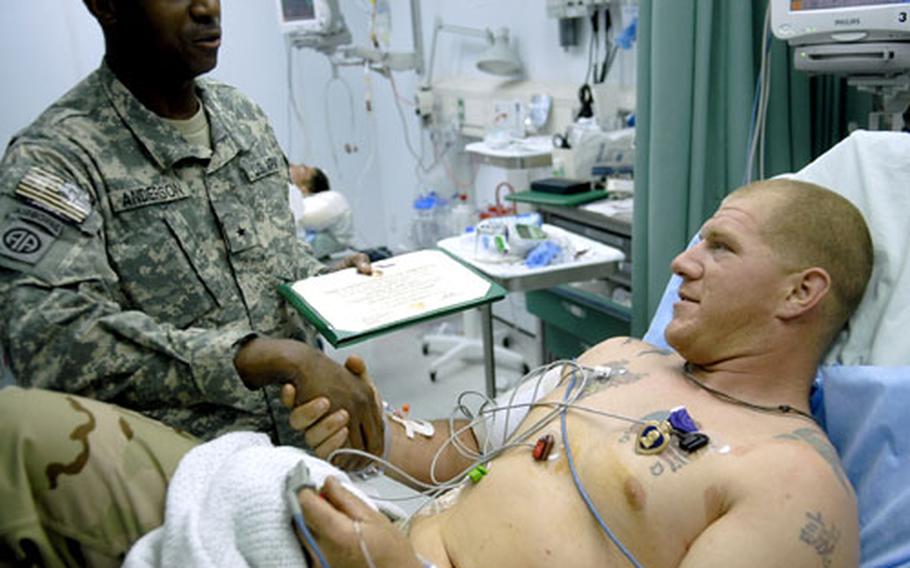 Spc. Adam Blackburn, 24, of Grant Bay, Calif., shakes the hand of Brig. Gen. Rodney O. Anderson after being awarded the Purple Heart Medal on Monday. Blackburn, wounded in combat in southern Afghanistan, is with the 82nd Airborne Division's 1st Battalion, 508th Parachute Infantry Regiment.