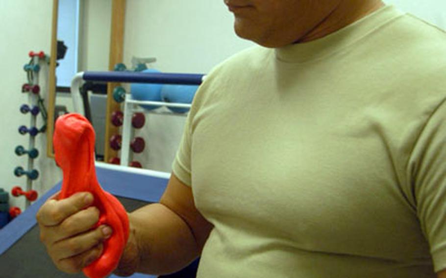 Staff Sgt. Leonard Day works with putty to get the strength back in his hand, wrist and arm during rehabilitation at the military medical clinic at Vicenza, Italy, recently. Day is one of more than 70 soldiers from the 173rd Airborne Brigade Combat Team who are currently recovering from wounds suffered in Afghanistan.