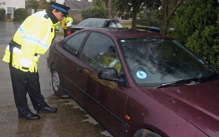 Police Community Support Officer Terry Joynson looks for security violations on an airman's vehicle during a "hot spot" patrol in June. British and U.S. Air Force police plan to step up the patrols in local villages after a recent increase in theft.