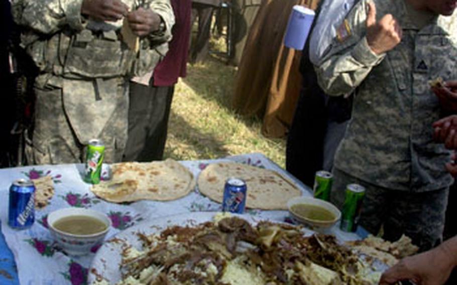 Sgt. 1st Class Robert Wilson goes for the bread and skips the lamb brains at a sheik meeting in Jurf As Sakhir, Iraq, recently.