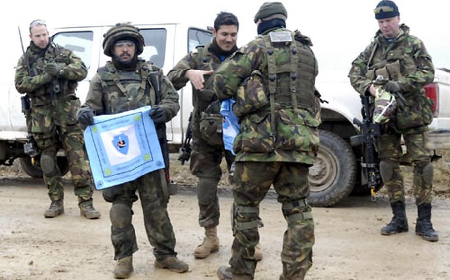 Afghan Army Sgt. Maj. Aminullah Sadiqi holds a flag presented by soldiers from the Dutch Army Wednesday following an exercise at a mock village in Hohenfels, Germany. The event brought together NATO forces with Afghan and U.S. soldiers in preparation for deployments to Afghanistan.