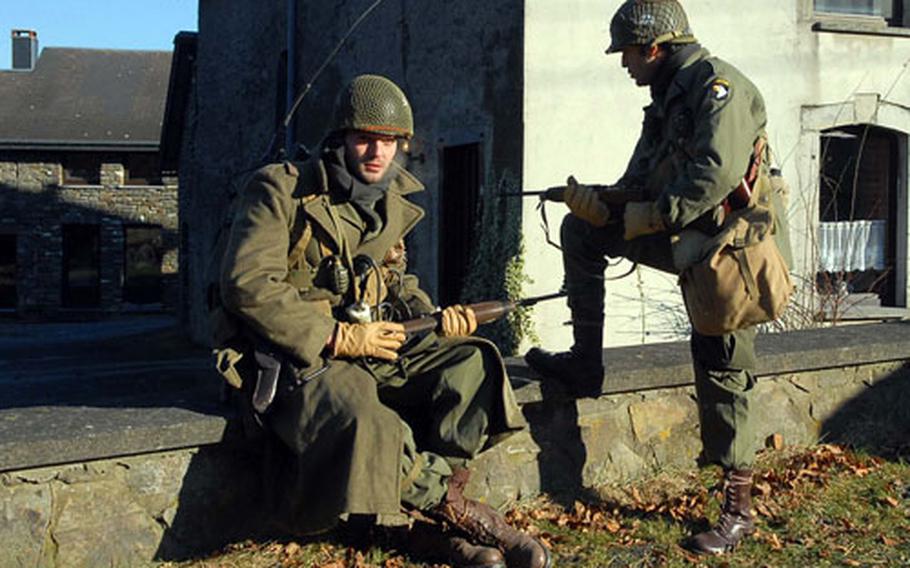 Like a scene out of a World War II movie, two re-enactors take a rest in Hemroulle, Belgium, during the 30th walk of the Bastogne perimeter commemorating the 63rd anniversary of the Battle of the Bulge.