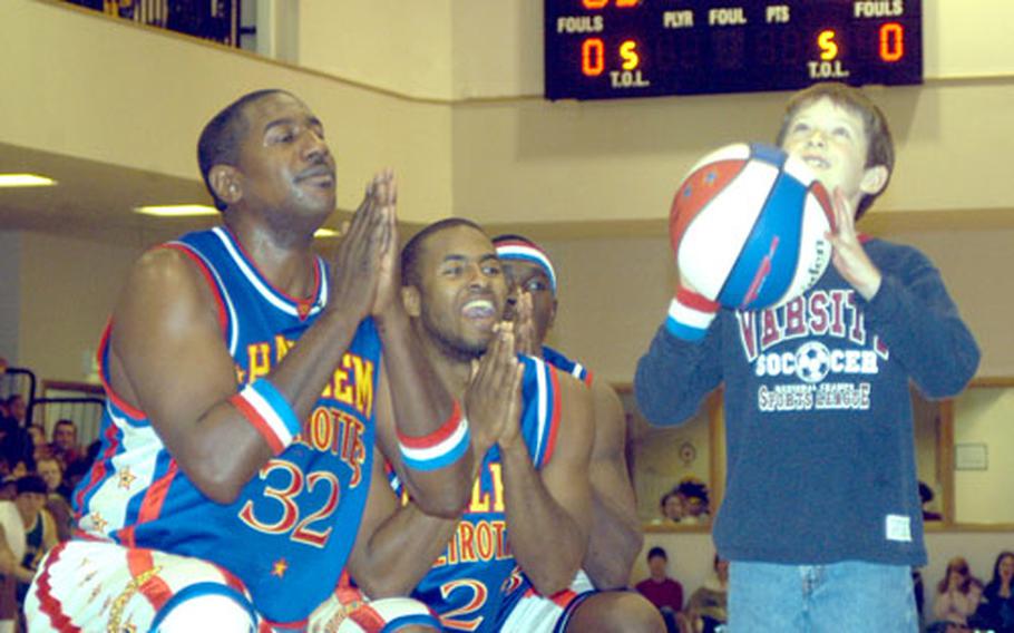 Harlem Globetrotter players "pray" for audience member Eli Gidlow, son of an RAF Lakenheath officer, to make a basket during a performance last week at RAF Mildenhall, the last stop on their tour of U.S. Air Force bases in Europe.