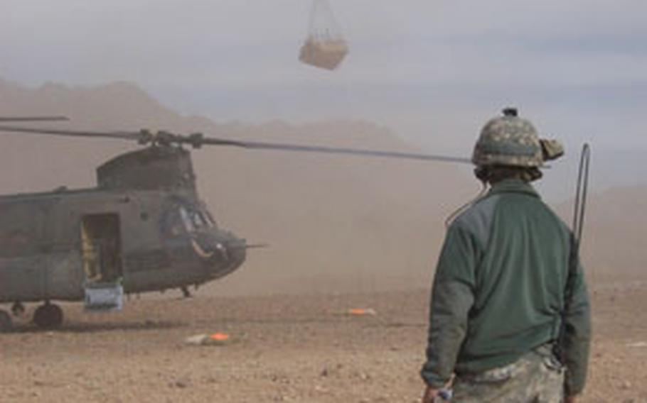 Second Platoon, Company A, 1st Battalion, 4th Infantry Regiment soldier Sgt. 1st Class Russell Johnson, 32, of Cumberland, Va., watches a Chinook helicopter sling-load supplies into Forward Operating Base Baylough in Zabul province, Afghanistan, on Sunday.