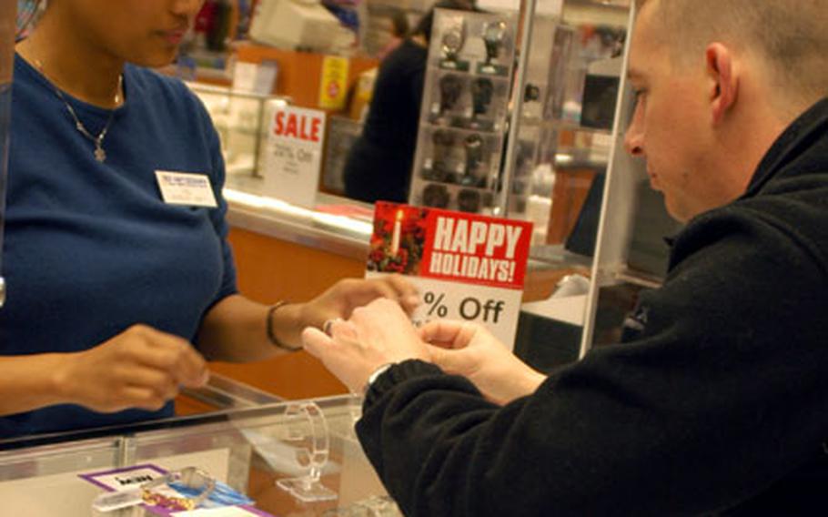 Ship movements delayed the Christmas shopping for Petty Officer 3rd Class Kevin White, who stopped in Yokosuka's Navy Exchange on Friday and was assisted in picking out a gift by jewelry department clerk Cel Harris.