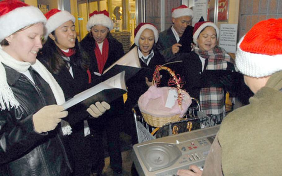 The Commander Fleet Activities Sasebo Carolers warm up Friday in front of the base Navy Exchange. The group was chosen as a semifinalist for NBC’s “Clash of the Choirs Holiday Challenge” earlier this month.